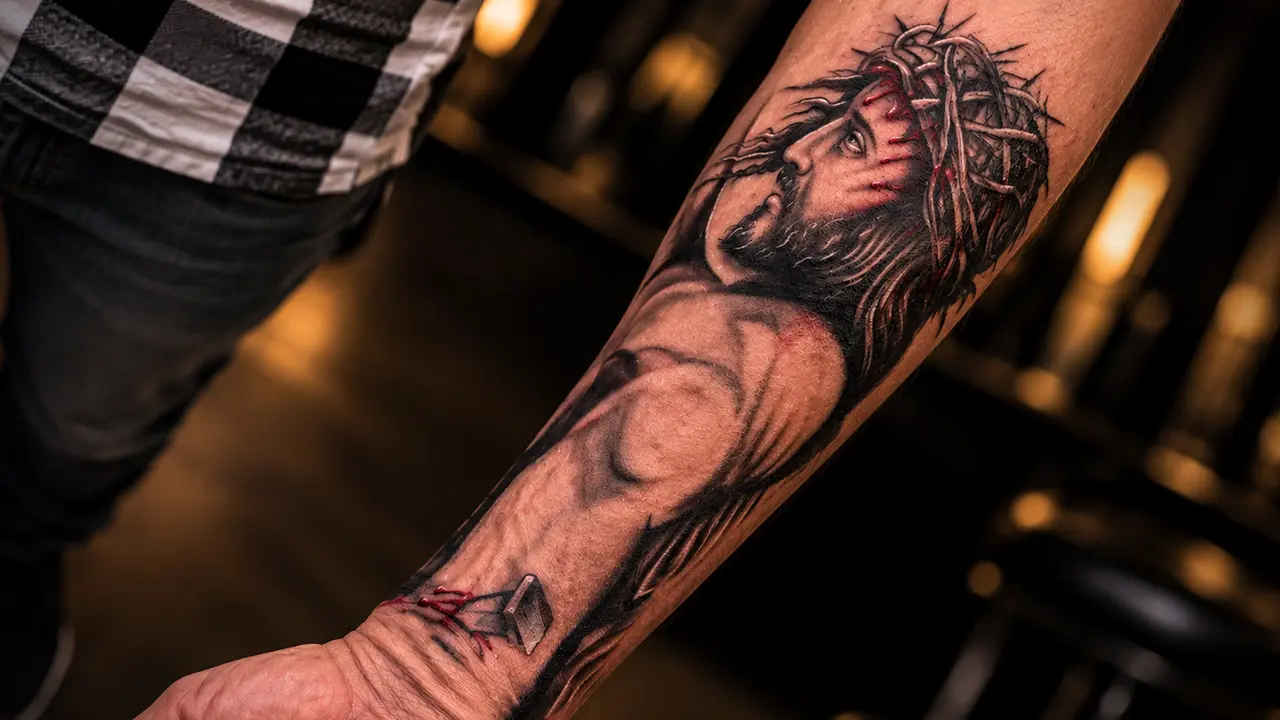 Tatuagem realista de Cristo no antebraço